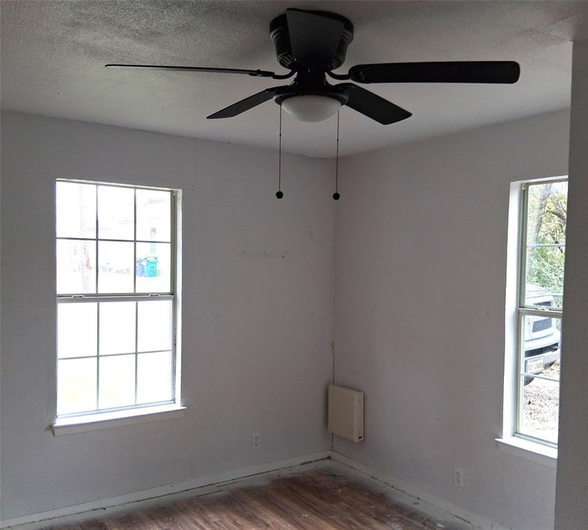 820 Allen Street Denton, TX 76205 - Photo 10 of 14 a lamp on a ceiling fan in a room next to a window