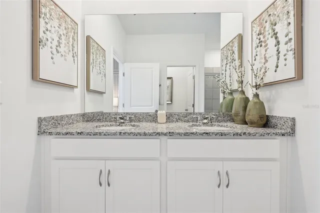 a bathroom with a granite countertop sink and a mirror