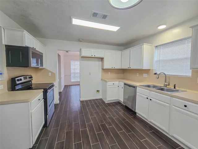 a kitchen with a sink stove top oven and cabinets