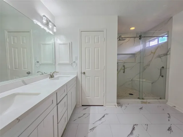 a bathroom with a double vanity sink and shower