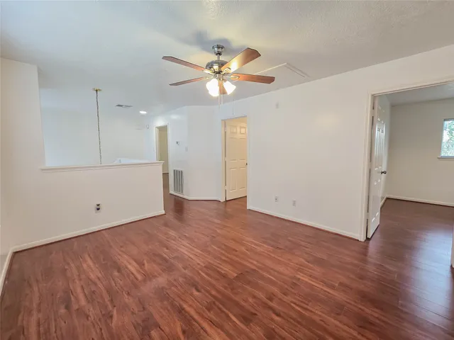 a view of a livingroom with a ceiling fan and wooden floor