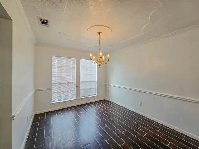 a view of wooden floor in an empty room with a window