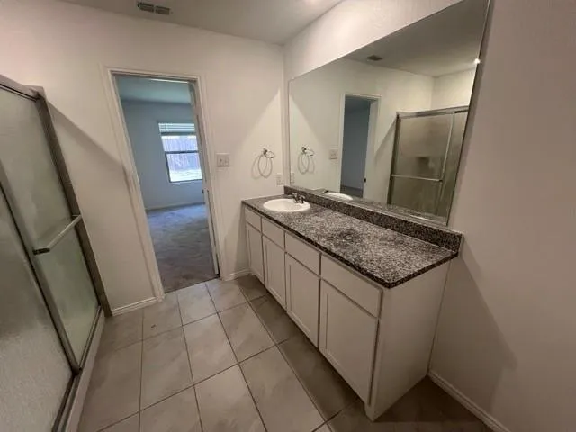 a bathroom with a granite countertop sink and a mirror