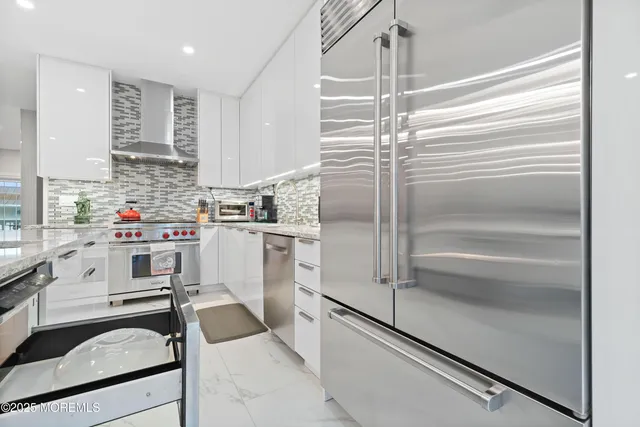 a utility room with stainless steel appliances granite countertop a stove and a sink