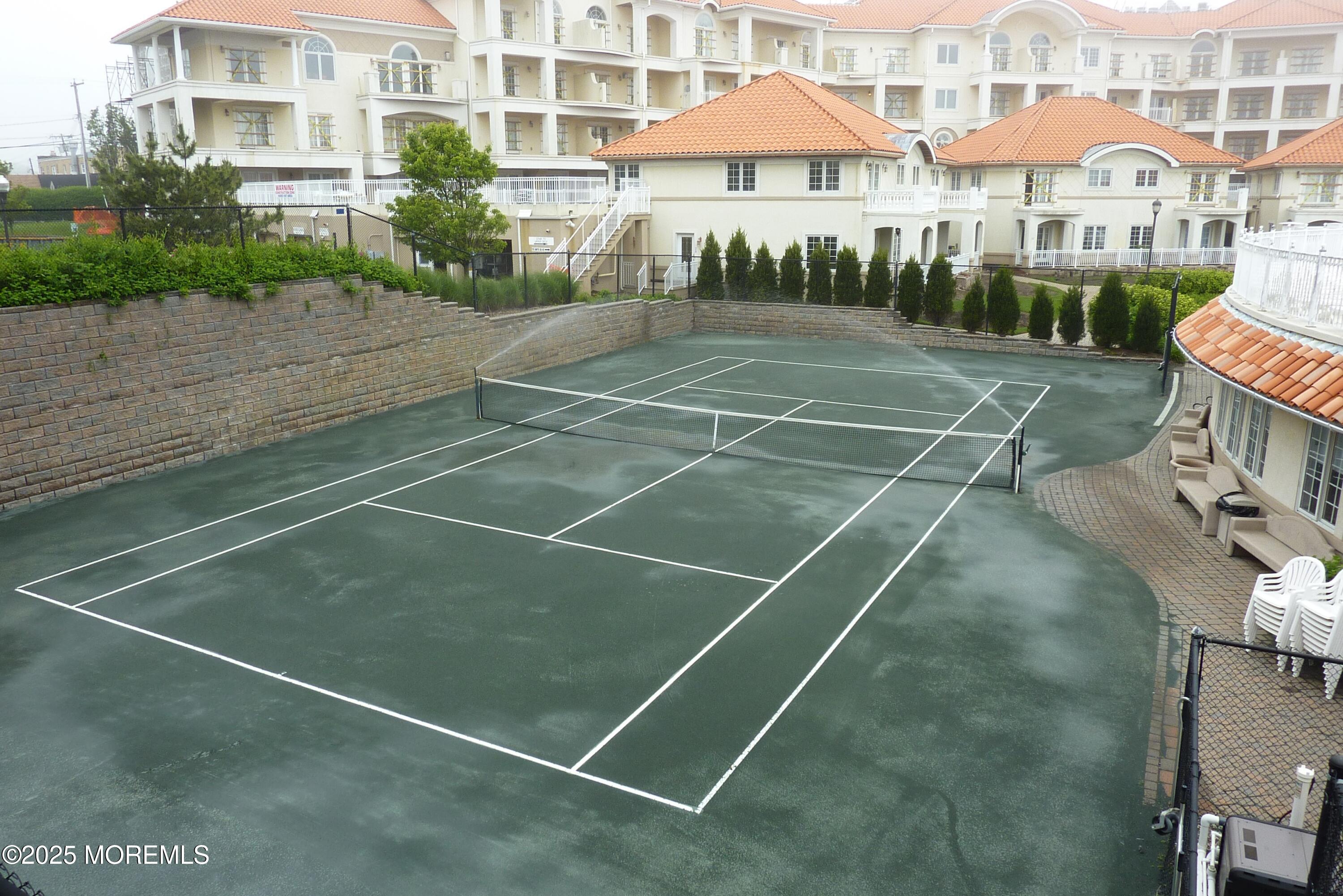 17 Riviera Drive Long Branch, NJ 07740 - Photo 44 of 52 a view of a tennis ground with a lawn chairs under an umbrella