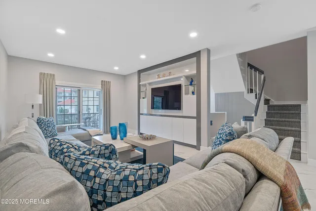 a living room with furniture and view of kitchen