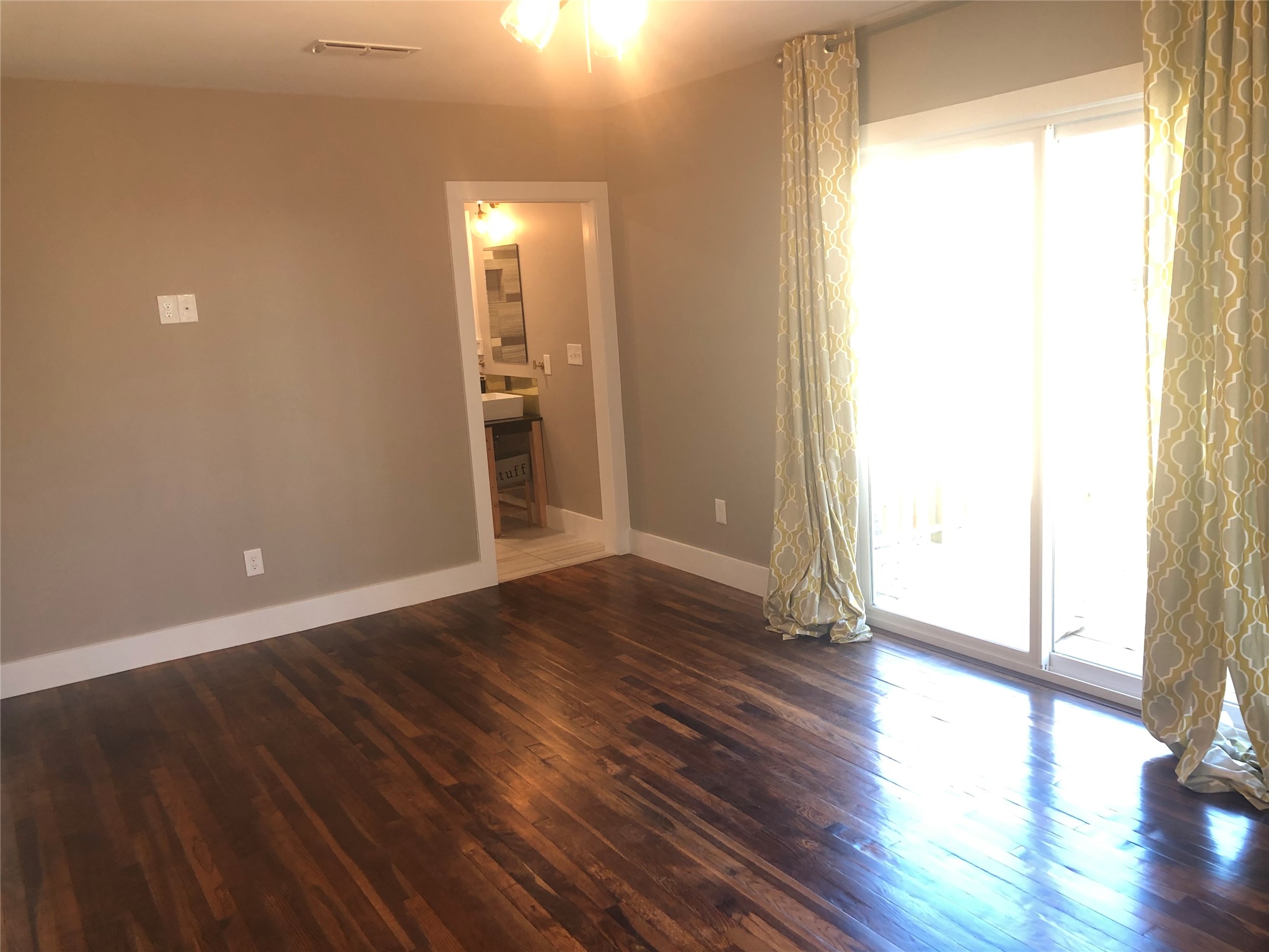 1221 South Austin Avenue Georgetown, TX 78626 - Photo 8 of 19 a view of an empty room with wooden floor and a window