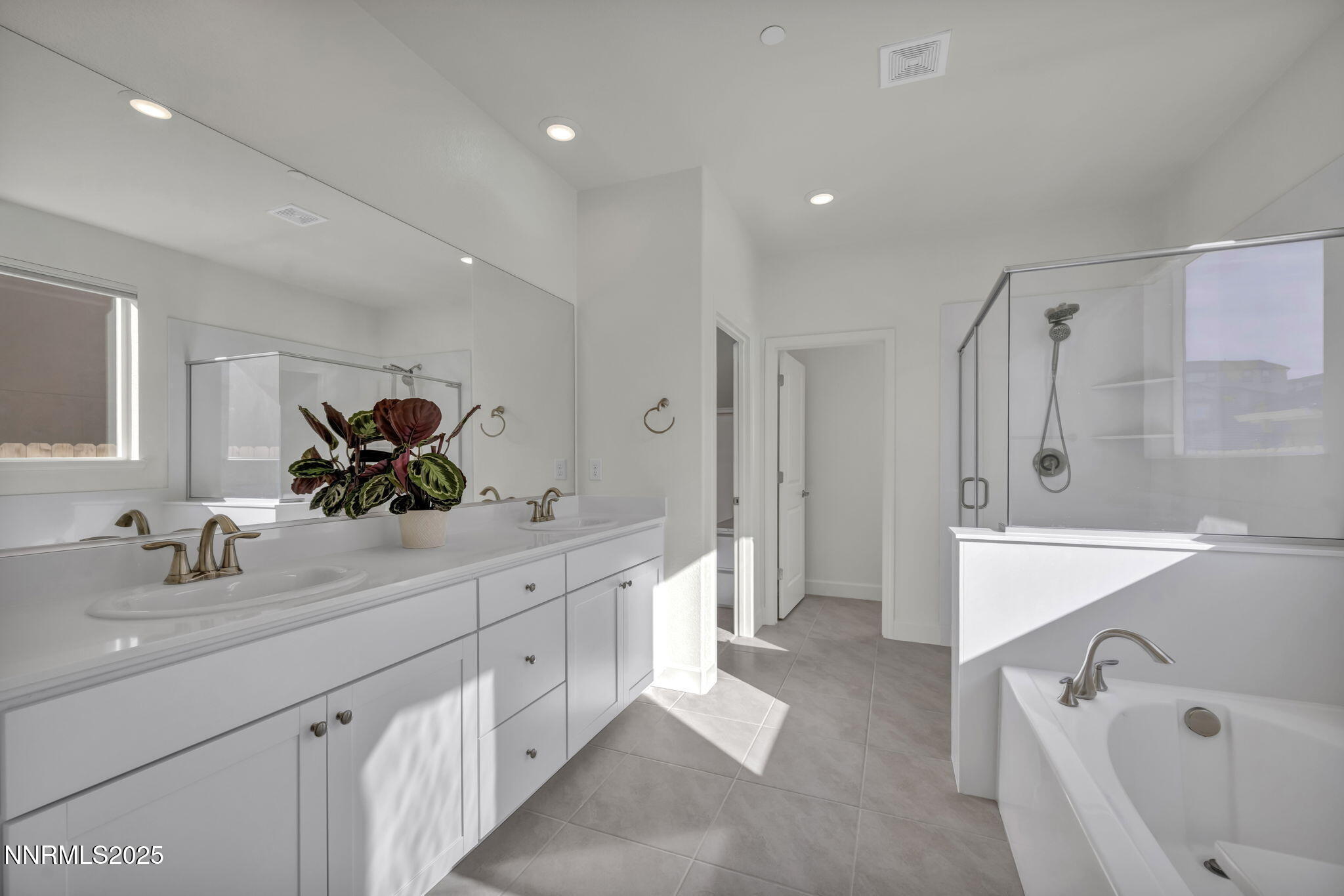 6870 Pilot Peak Road Sparks, NV 89436 - Photo 12 of 55 a bathroom with a double vanity sink a mirror a bathtub and shower