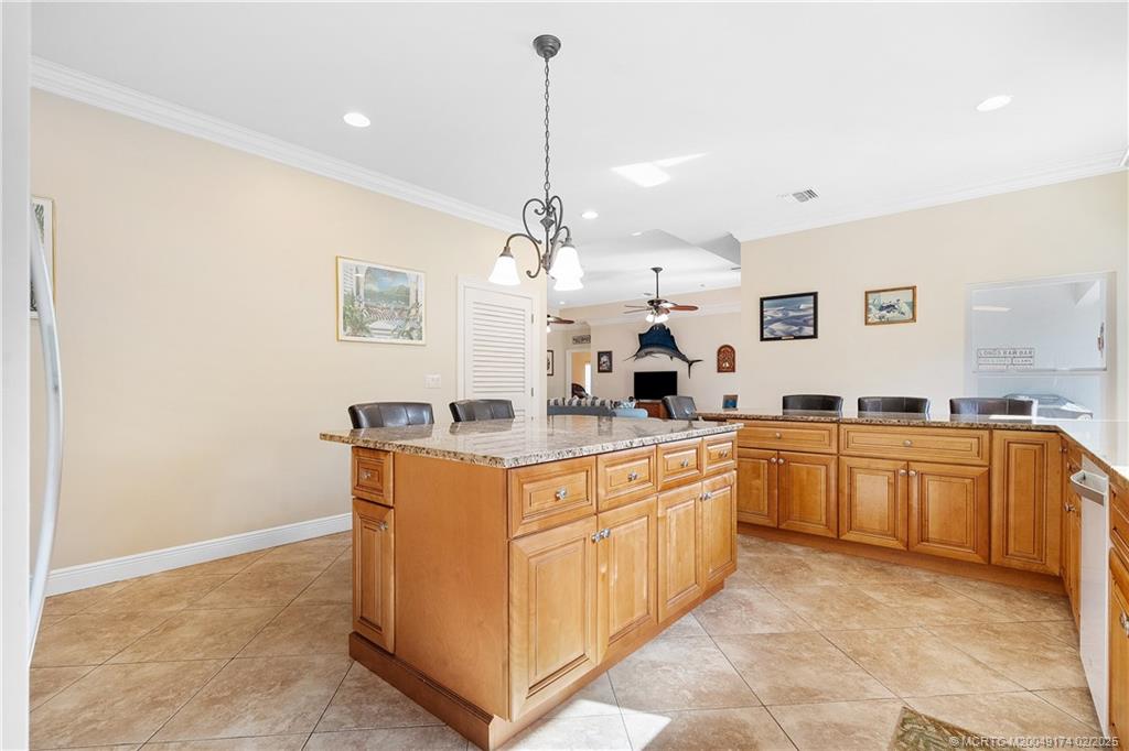 4732 Starling Way Stuart, FL 34997 - Photo 18 of 43 a large kitchen with kitchen island granite countertop lots of white cabinets