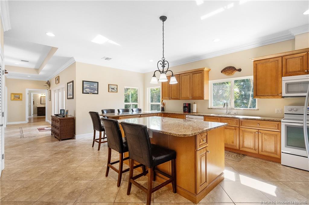 4732 Starling Way Stuart, FL 34997 - Photo 19 of 43 a open kitchen with stainless steel appliances granite countertop a stove and refrigerator