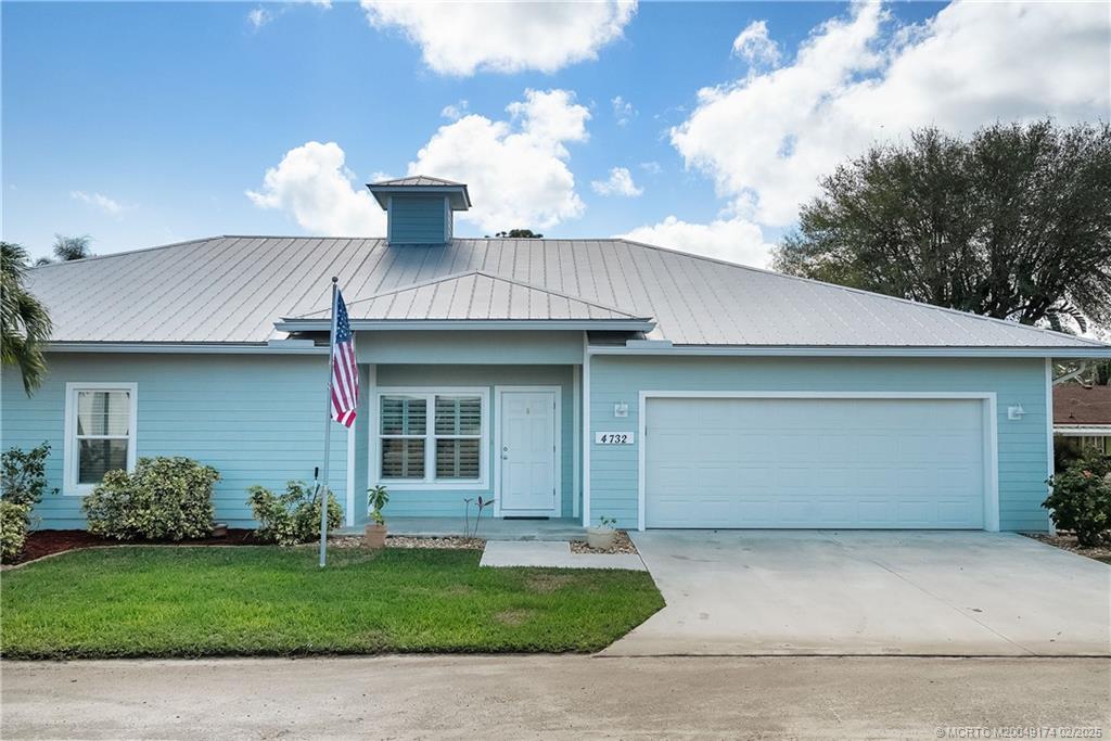 4732 Starling Way Stuart, FL 34997 - Photo 36 of 43 a front view of a house with a garden and garage