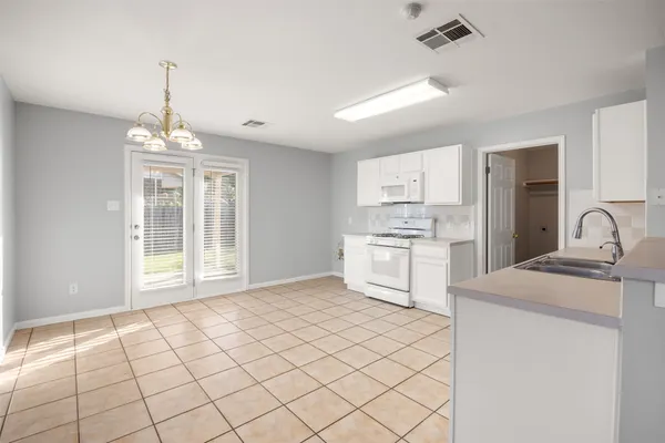 a kitchen with white cabinets and white appliances