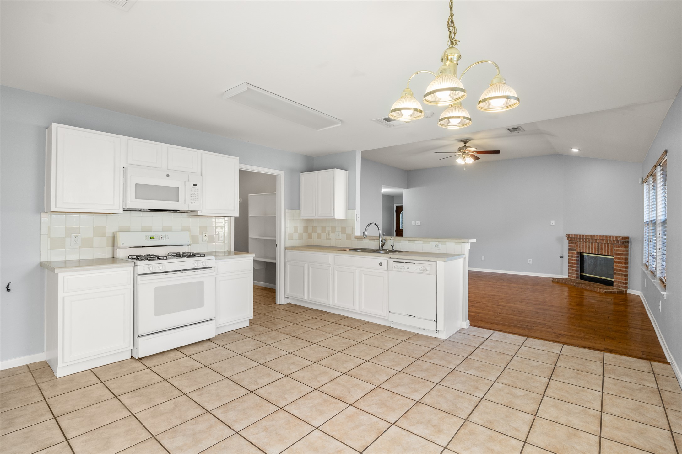 121 Primrose Boulevard Kyle, TX 78640 - Photo 19 of 19 a kitchen with a stove a sink and a refrigerator
