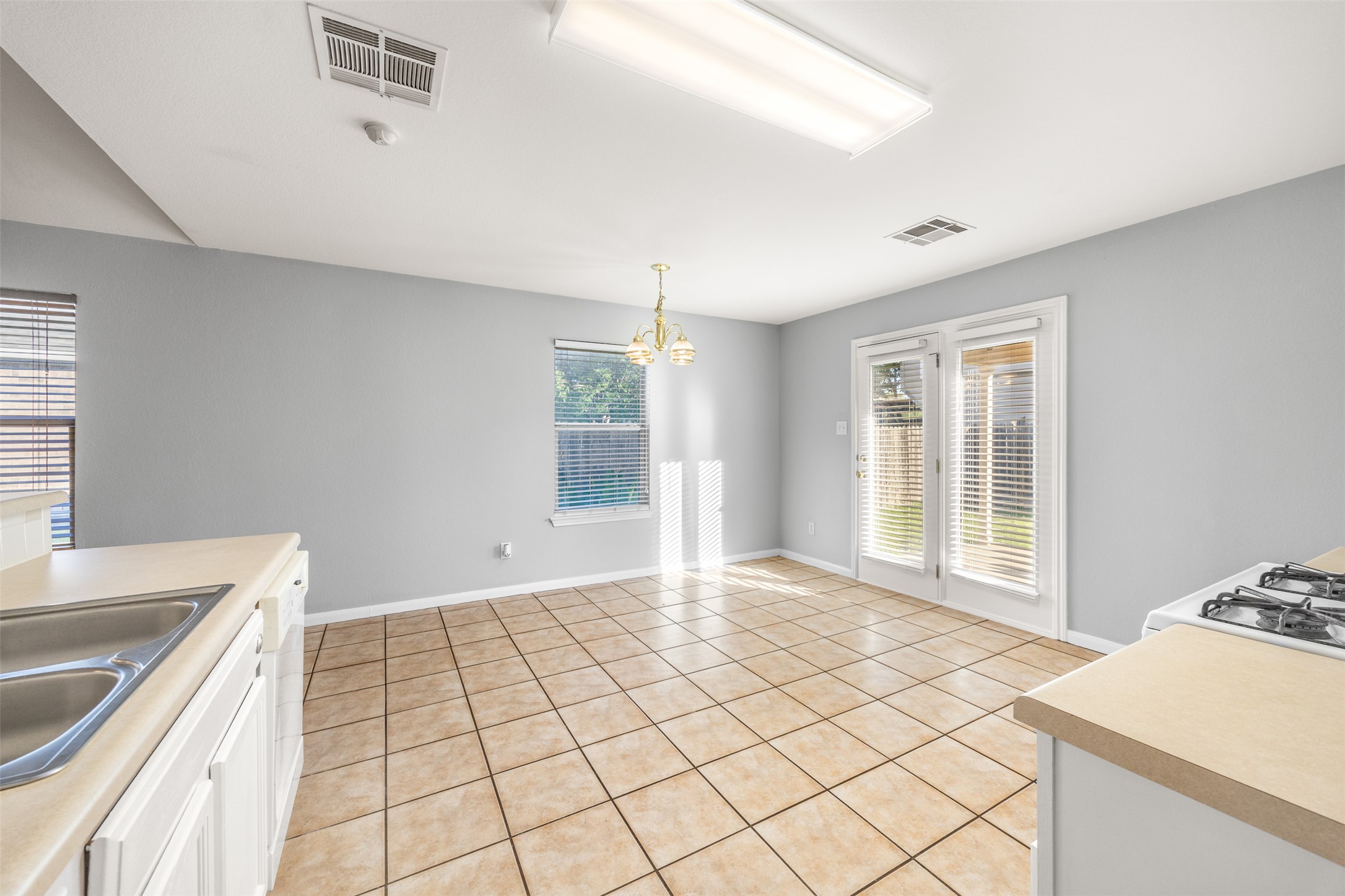 121 Primrose Boulevard Kyle, TX 78640 - Photo 14 of 19 a view of a kitchen with a sink and dishwasher with wooden floor