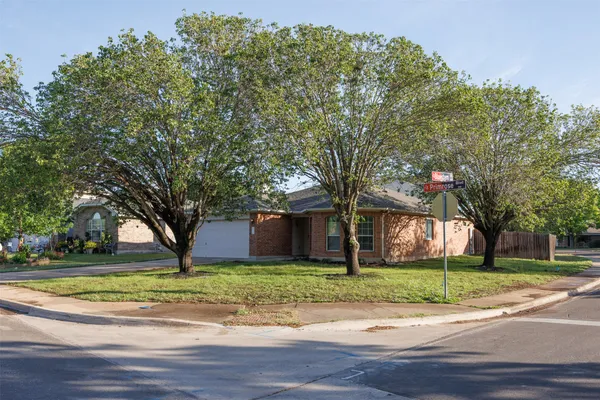 a view of a house with a big yard and large trees