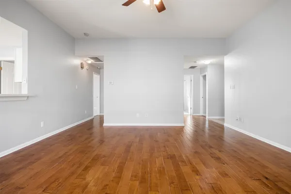 a view of an empty room with wooden floor