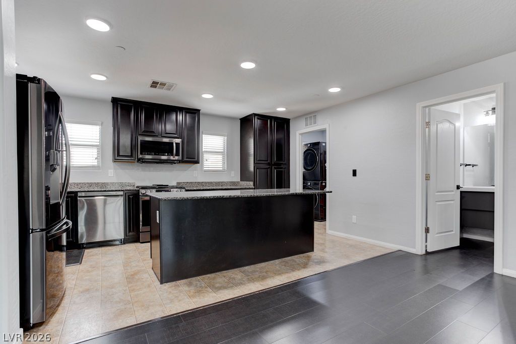 7724 Vibrant Thread Court Las Vegas, NV 89149 - Photo 8 of 43 Dark wood cabinetry and gleaming stainless steel appliances adorn this spacious culinary haven.