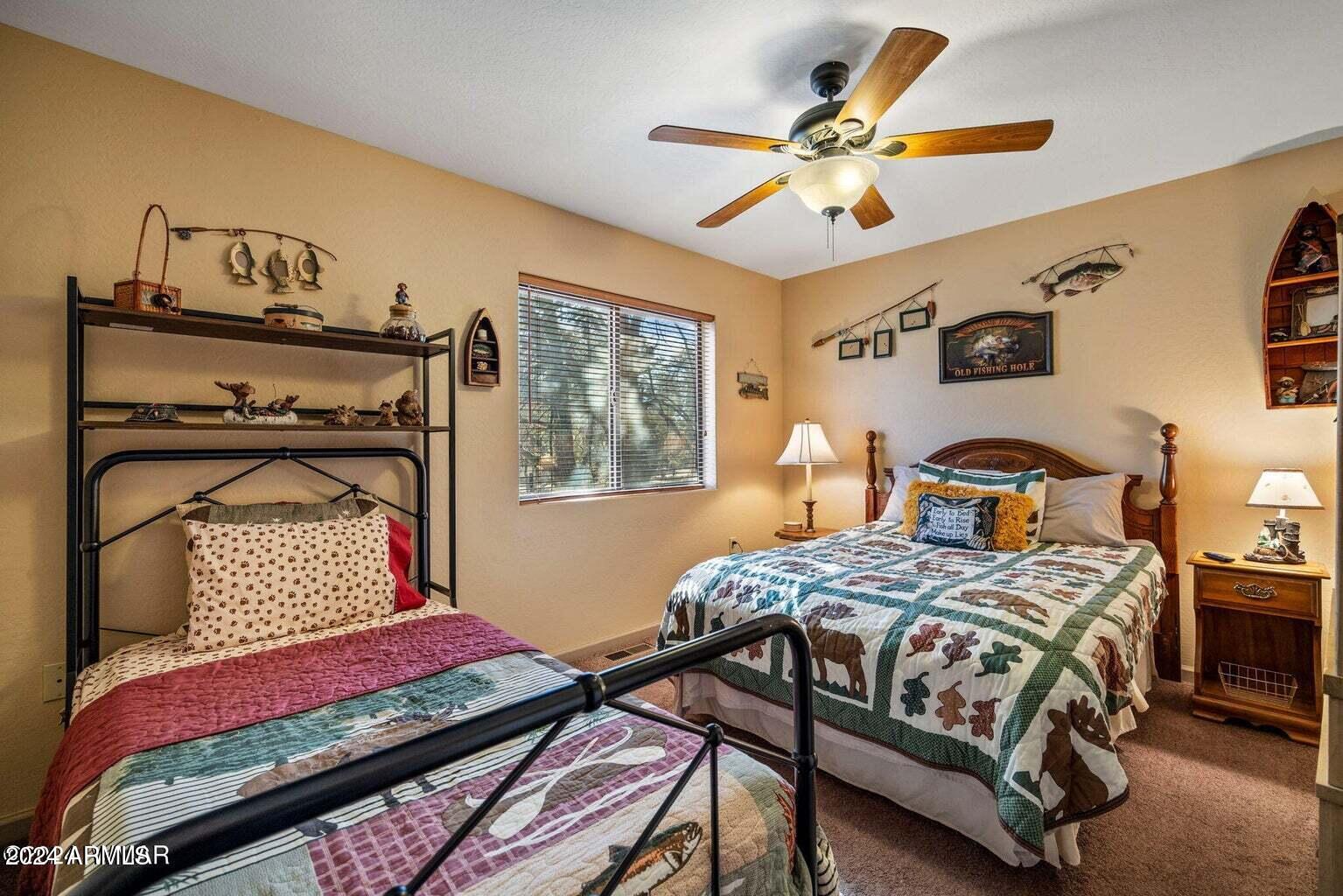 2086 Pinewood Drive Overgaard, AZ 85933 - Photo 22 of 33 a bedroom with a bed and a chandelier