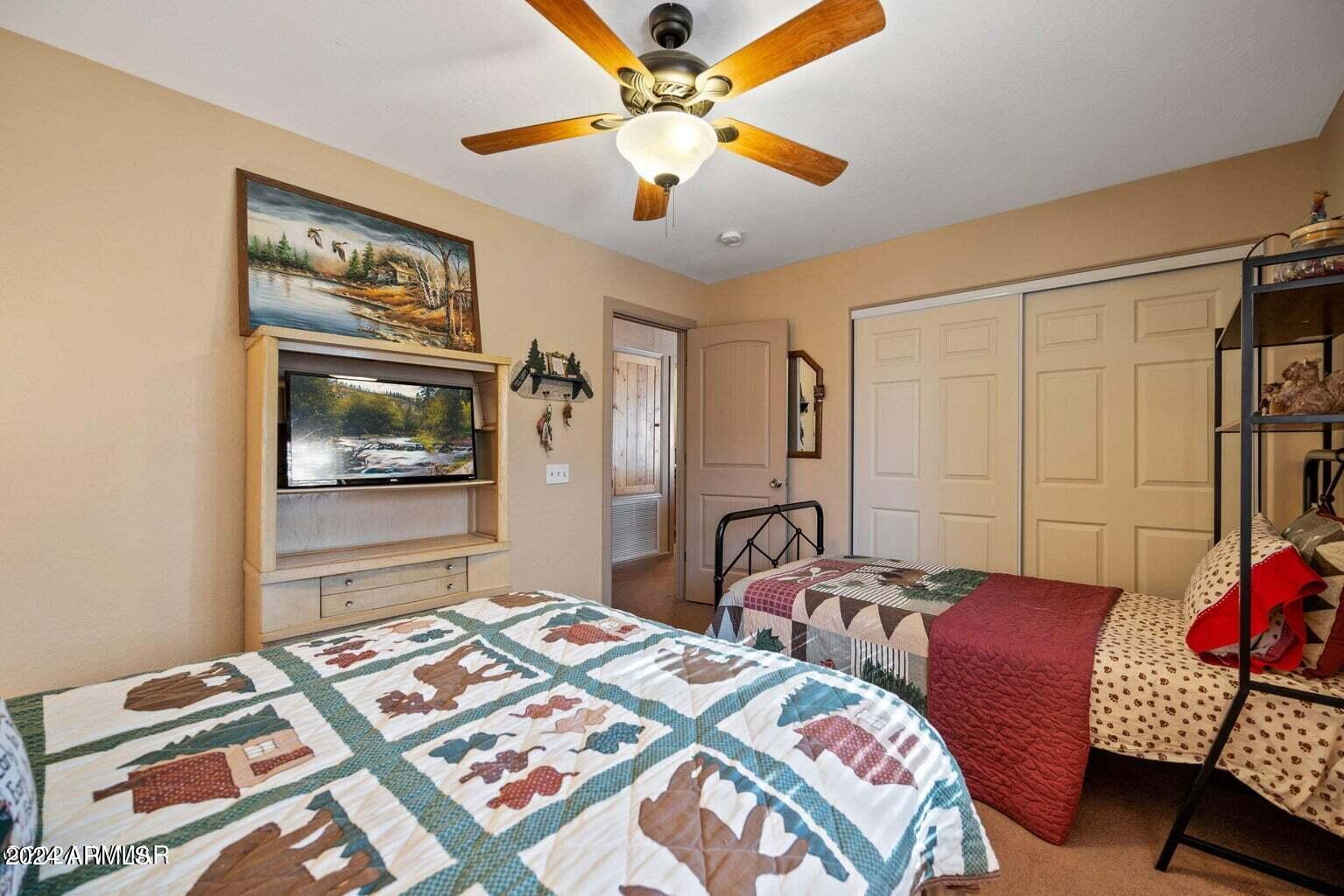 2086 Pinewood Drive Overgaard, AZ 85933 - Photo 23 of 33 a bedroom with a bed and a chandelier