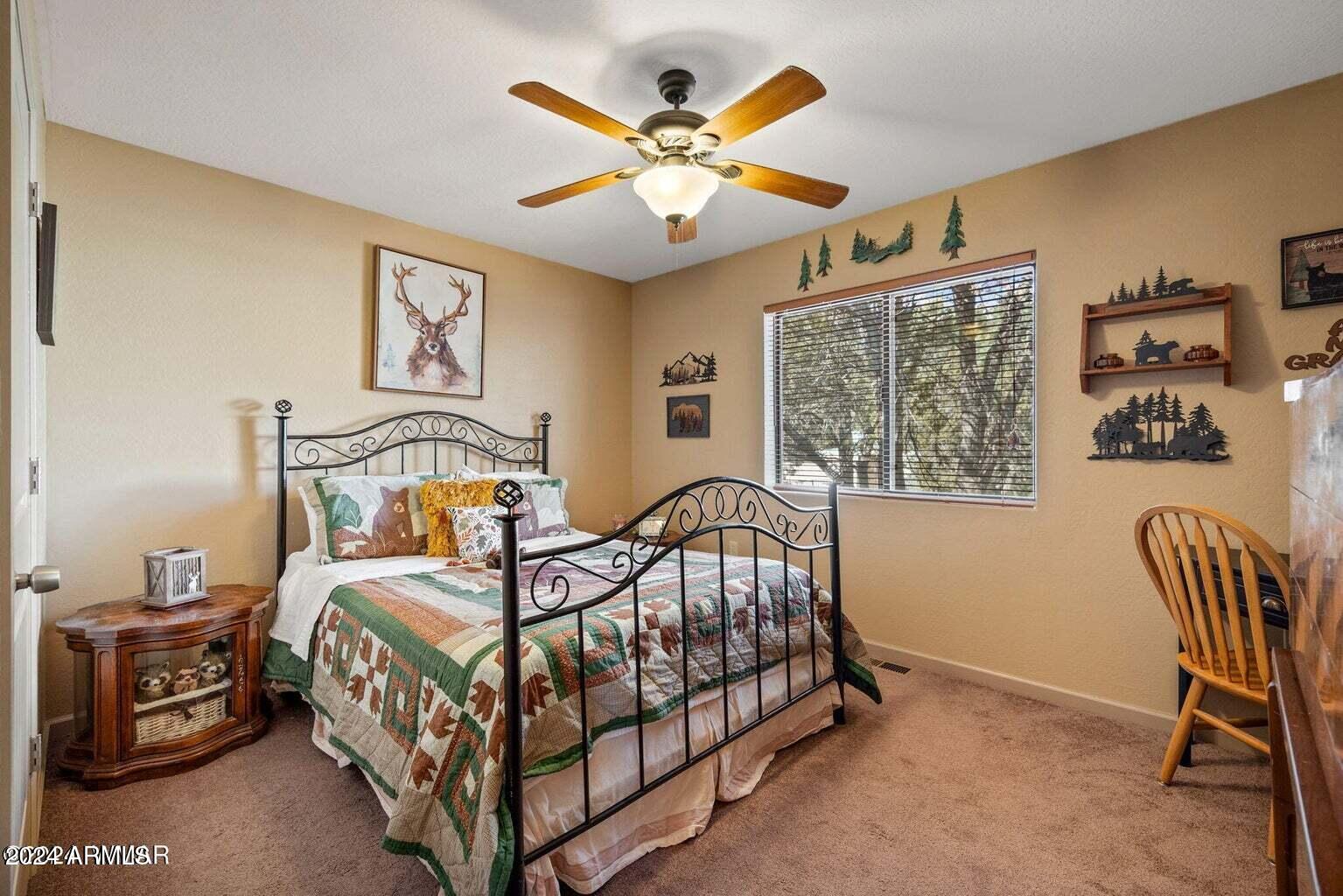 2086 Pinewood Drive Overgaard, AZ 85933 - Photo 26 of 33 a bedroom with a bed and a chandelier
