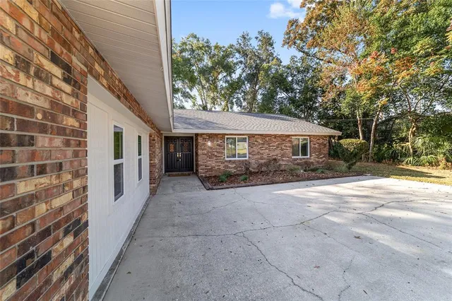 a large kitchen with a large counter top a sink stainless steel appliances and cabinets