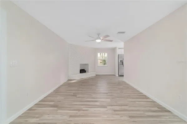 a kitchen with granite countertop a stove a sink and white cabinets with wooden floor