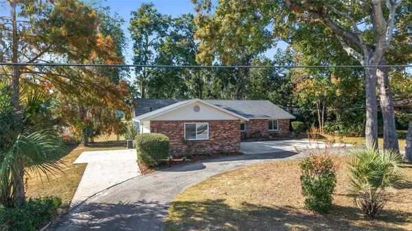 a large white kitchen with stainless steel appliances kitchen island a stove a refrigerator a table and chairs