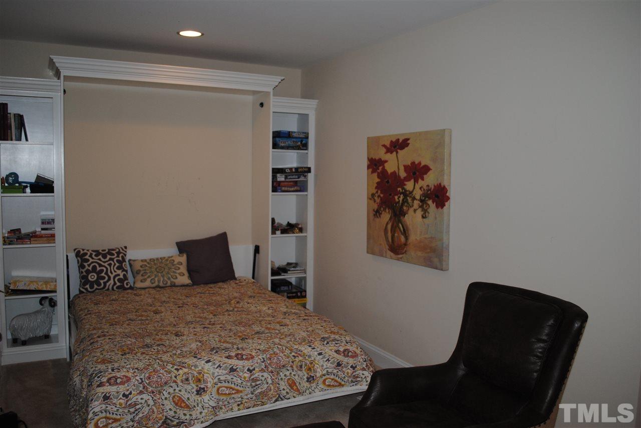 2352 Noble Road Raleigh, NC 27608 - Photo 19 of 24 a bedroom with a bed and a chair