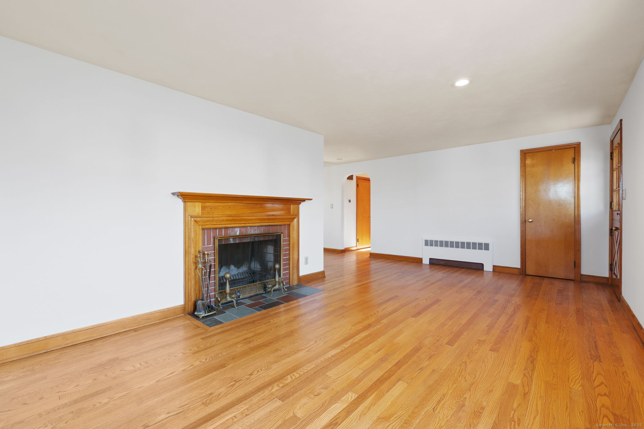 95 Tuttle Street Bristol, CT 06010 - Photo 8 of 28 an empty room with wooden floor and fireplace