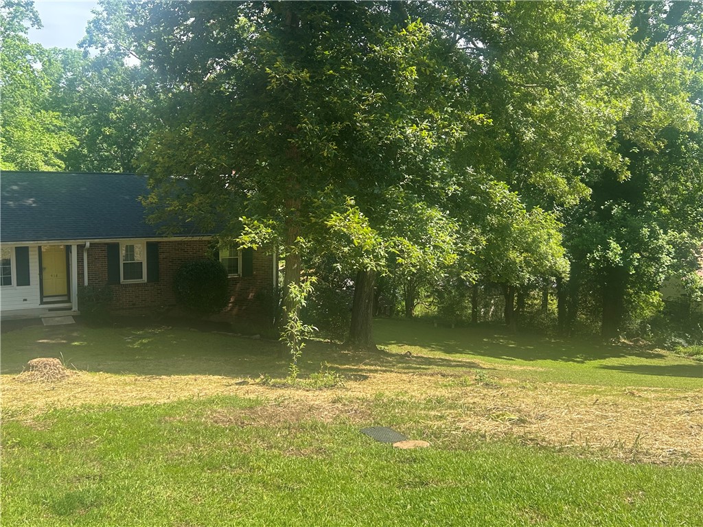 418 Saluda Road Williamston, SC 29697 - Photo 3 of 40 Mature trees frame this traditional brick home, offering shaded comfort and ample yard space.