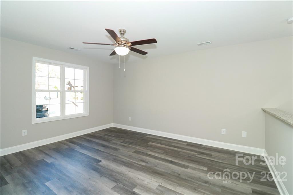 287 Sunderland Road Southwest Concord, NC 28027 - Photo 5 of 16 an empty room with wooden floor fan and windows