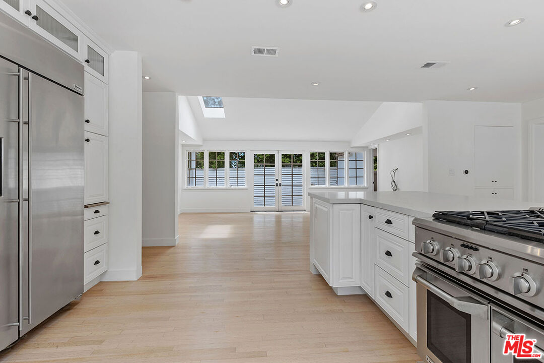 1462 Rising Glen Road Los Angeles, CA 90069 - Photo 18 of 40 a kitchen with granite countertop a stove and cabinets