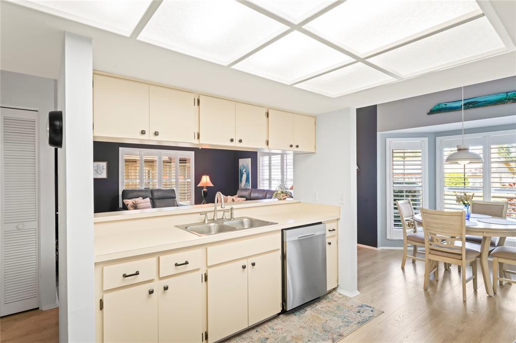 7107 Pond View Court Spring Hill, FL 34606 - Photo 13 of 100 a kitchen with a sink stove and white cabinets with wooden floor