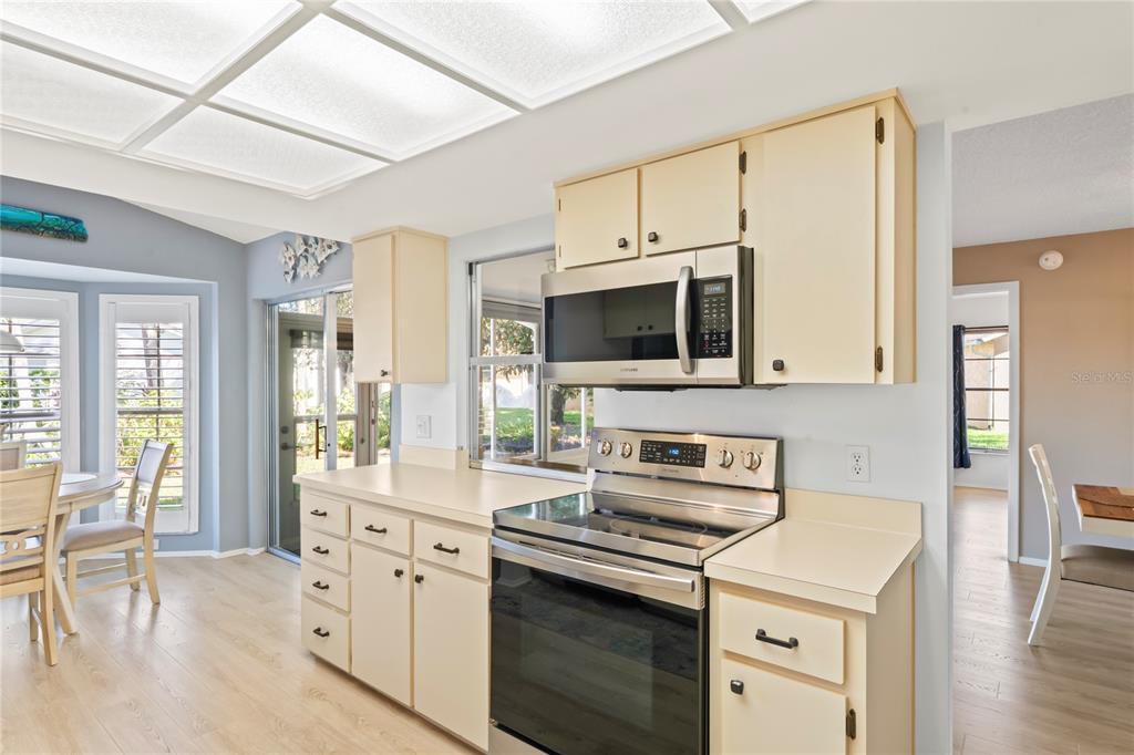 7107 Pond View Court Spring Hill, FL 34606 - Photo 14 of 100 a kitchen with stainless steel appliances a stove microwave and a refrigerator