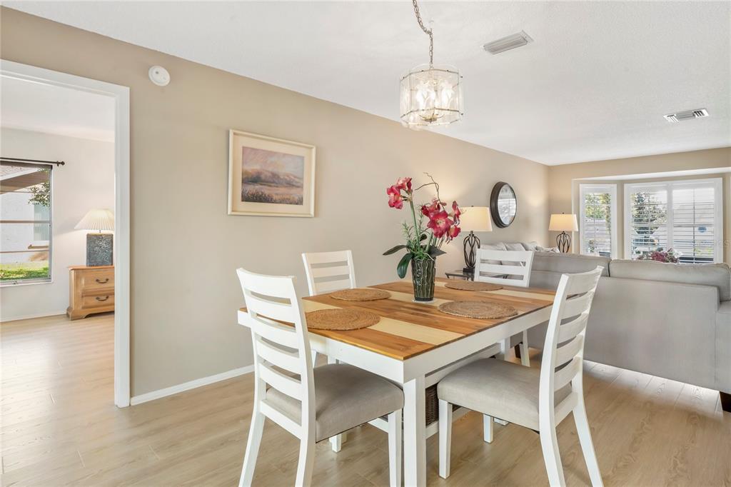 7107 Pond View Court Spring Hill, FL 34606 - Photo 22 of 100 a view of a dining room with furniture and wooden floor