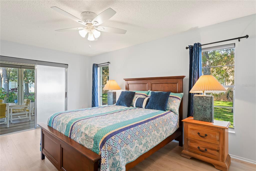 7107 Pond View Court Spring Hill, FL 34606 - Photo 30 of 100 a bedroom with a bed and a chandelier