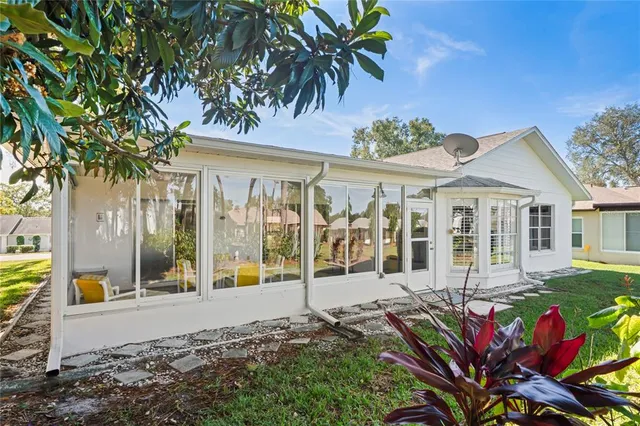 a view of a white house with a big yard and large trees