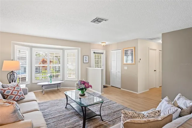 a kitchen with a sink stove and white cabinets with wooden floor