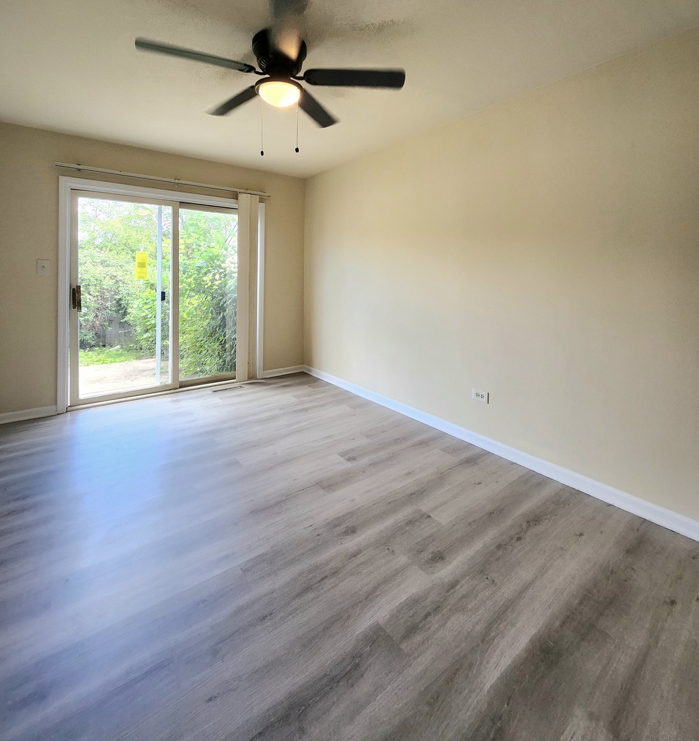 818 Concord Lane, Unit 818 Barrington, IL 60010 - Photo 6 of 16 an empty room with wooden floor and windows