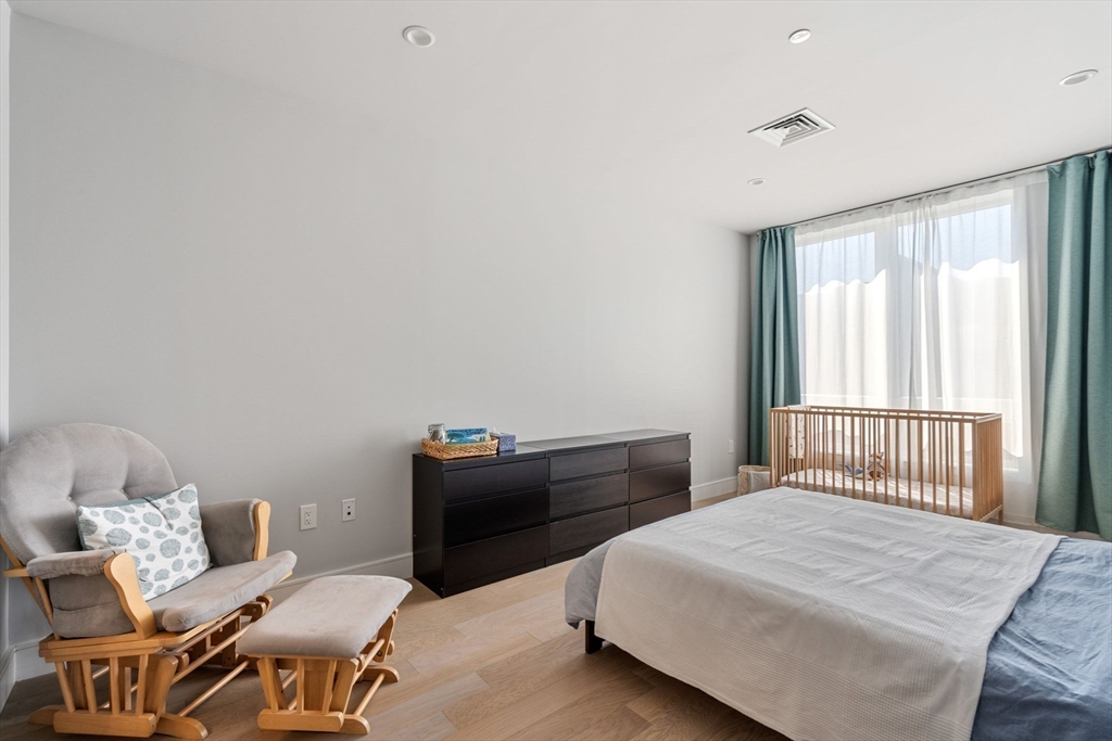44-50 Symphony Road, Unit 403 Boston, MA 02115 - Photo 14 of 28 a bedroom with a bed and wooden floor