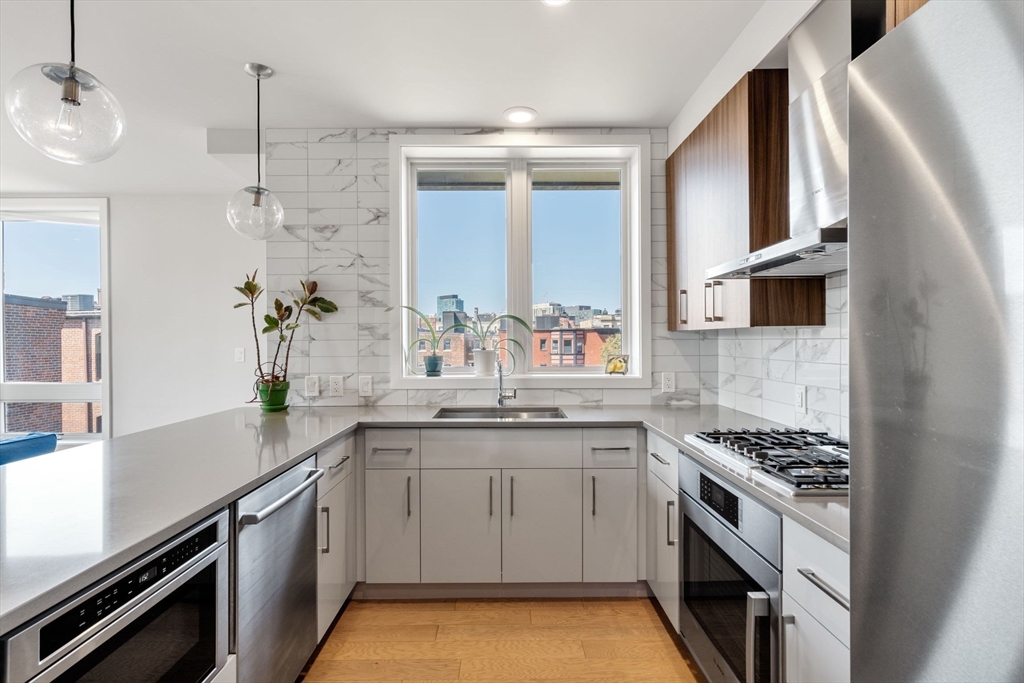 44-50 Symphony Road, Unit 403 Boston, MA 02115 - Photo 19 of 28 a kitchen with a sink stove and cabinets