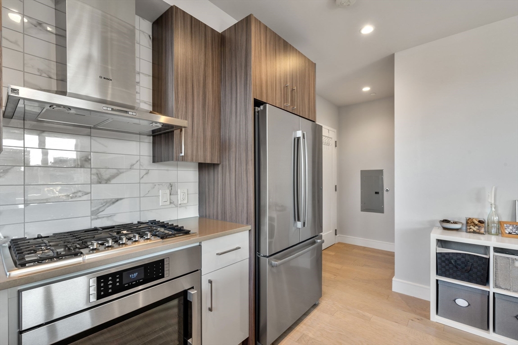 44-50 Symphony Road, Unit 403 Boston, MA 02115 - Photo 21 of 28 a kitchen with stainless steel appliances a stove a refrigerator and cabinets