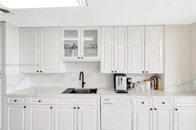 a kitchen with stainless steel appliances white cabinets a sink and a window