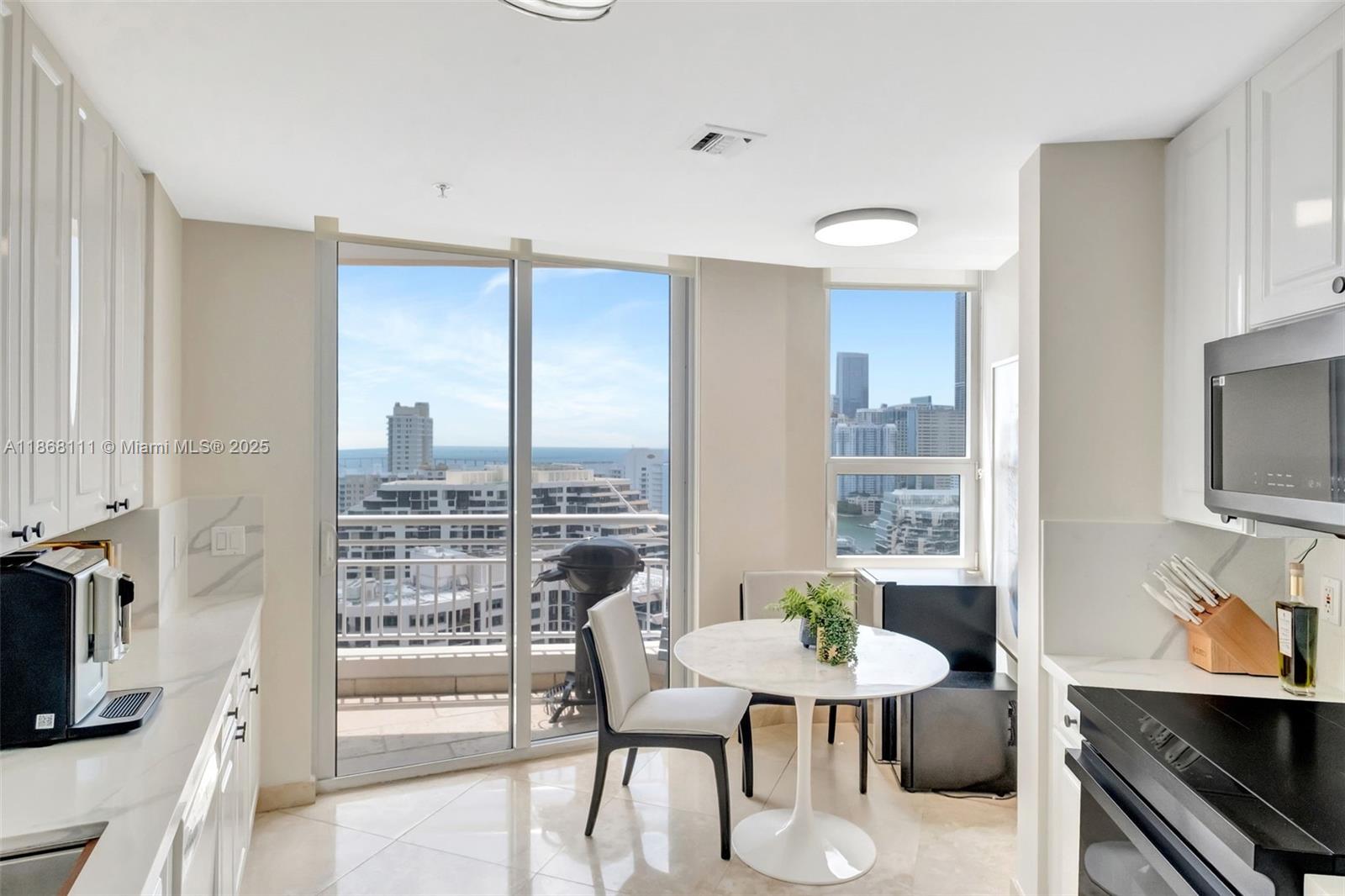 848 Brickell Key Drive, Unit 2605 Miami, FL 33131 - Photo 13 of 35 a view of a dining room with furniture window and wooden floor