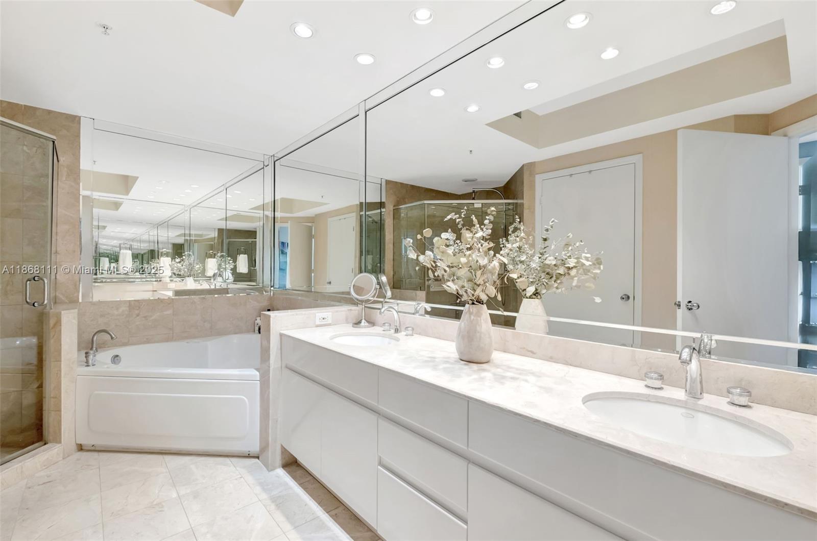 848 Brickell Key Drive, Unit 2605 Miami, FL 33131 - Photo 17 of 35 a bathroom with a tub sink and mirror