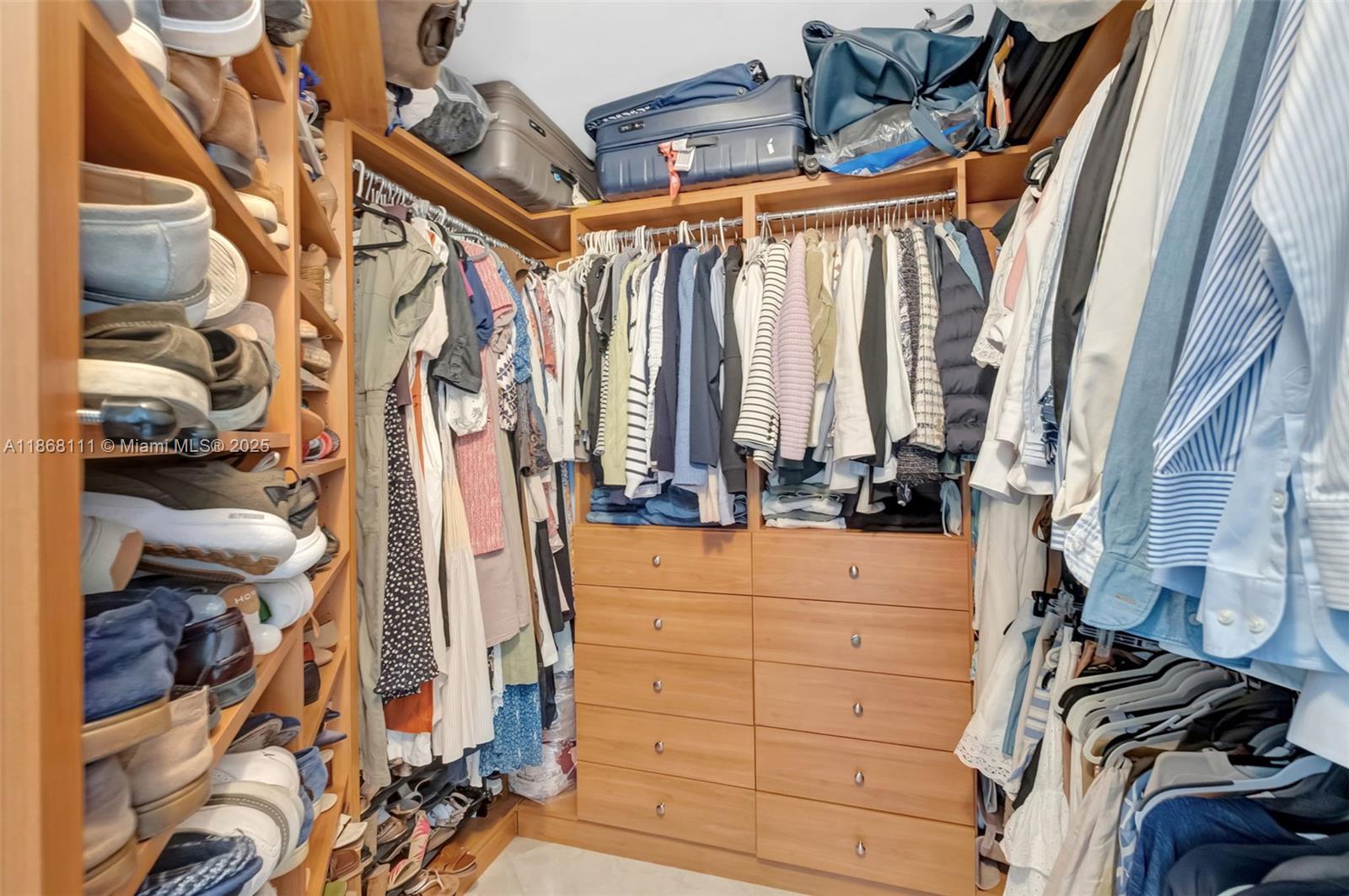 848 Brickell Key Drive, Unit 2605 Miami, FL 33131 - Photo 19 of 35 a view of walk in closet with clothes and shoes