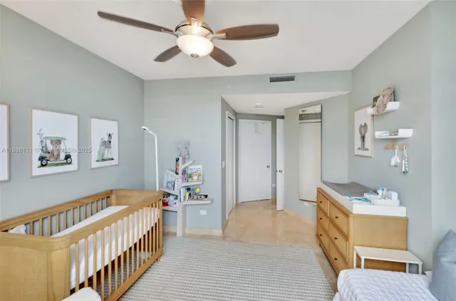 a view of a bedroom with wooden floor and a ceiling fan