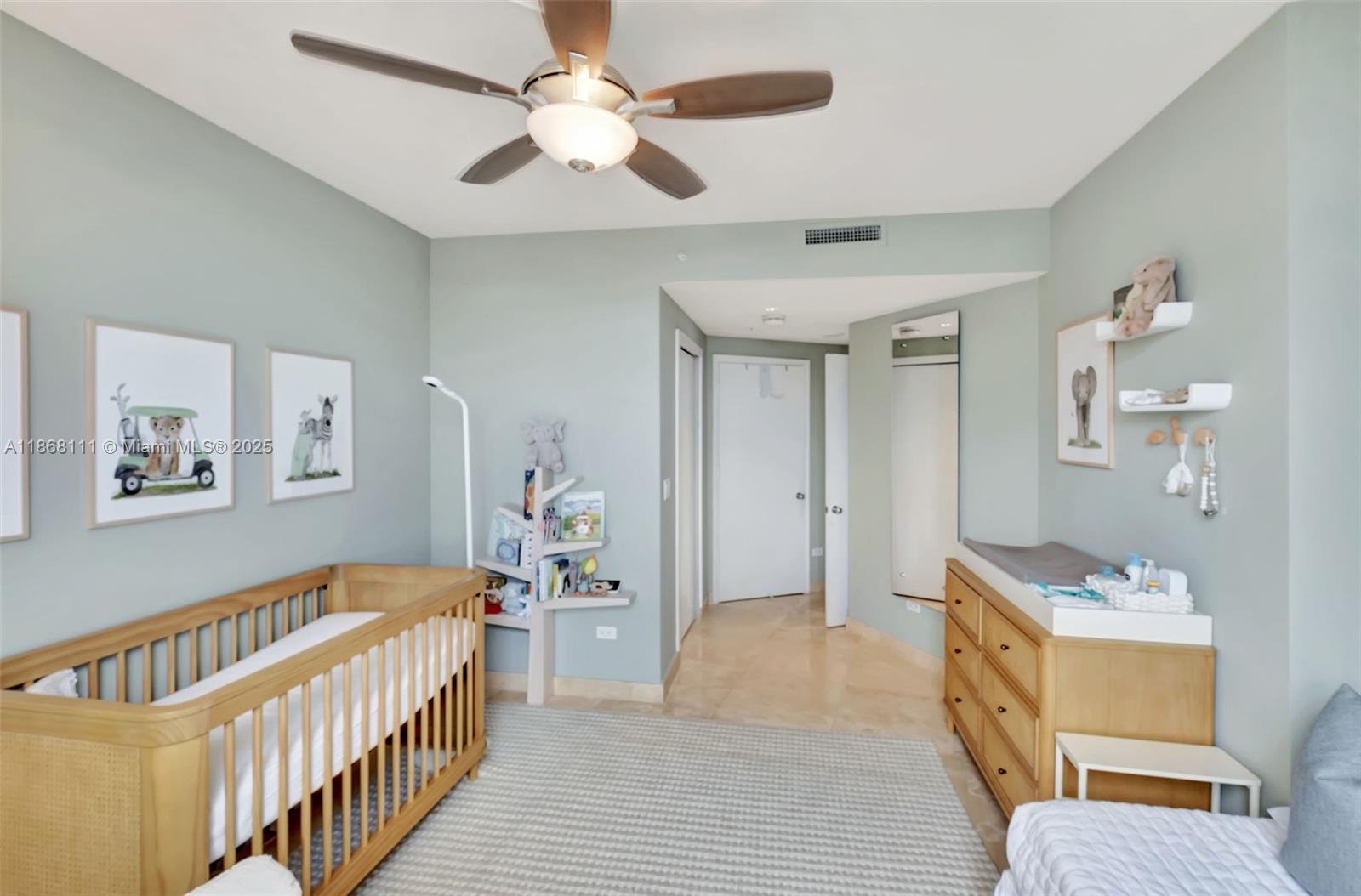 848 Brickell Key Drive, Unit 2605 Miami, FL 33131 - Photo 21 of 35 a view of a bedroom with wooden floor and a ceiling fan