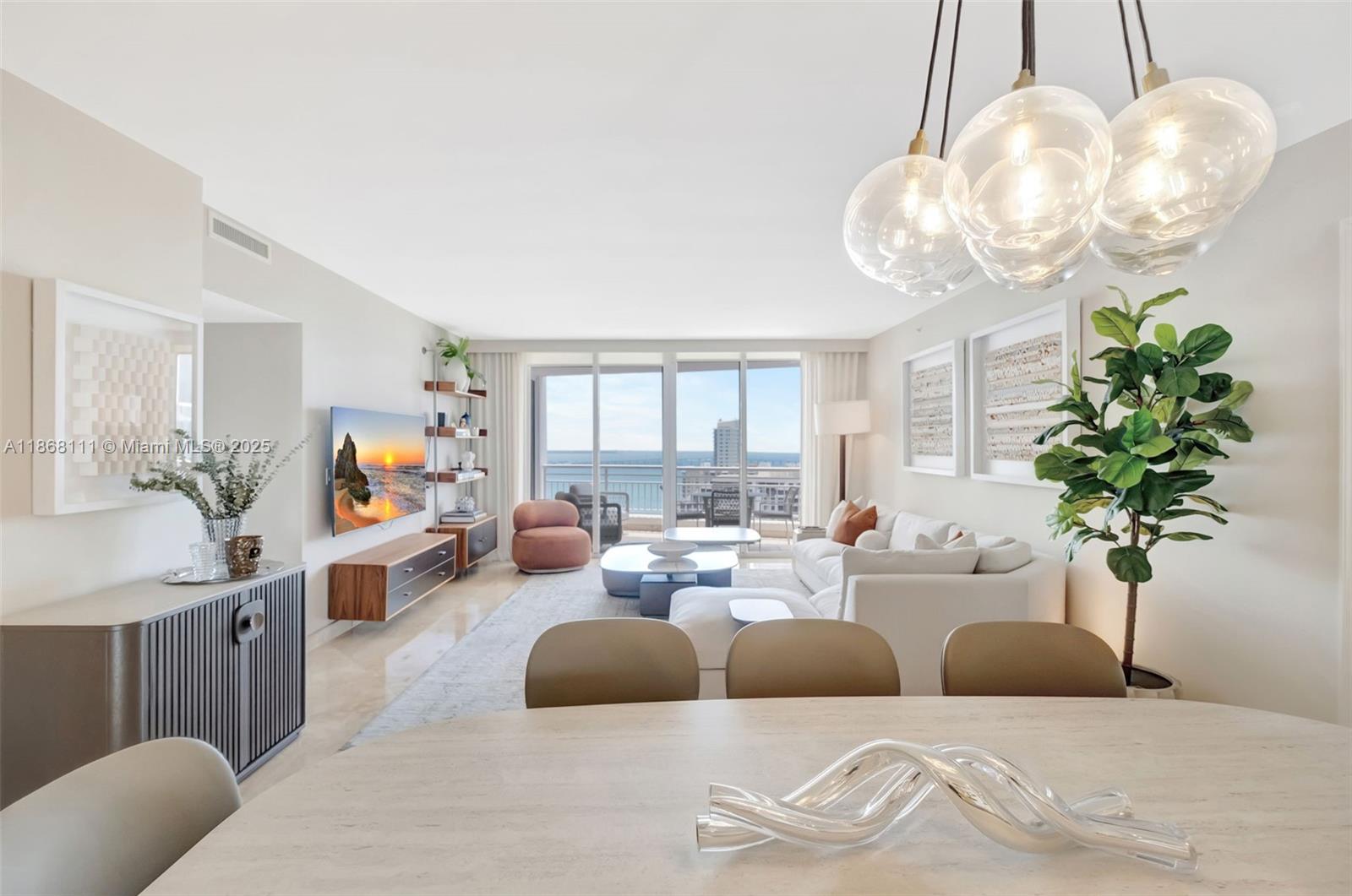 848 Brickell Key Drive, Unit 2605 Miami, FL 33131 - Photo 8 of 35 a living room with furniture flowers and a chandelier