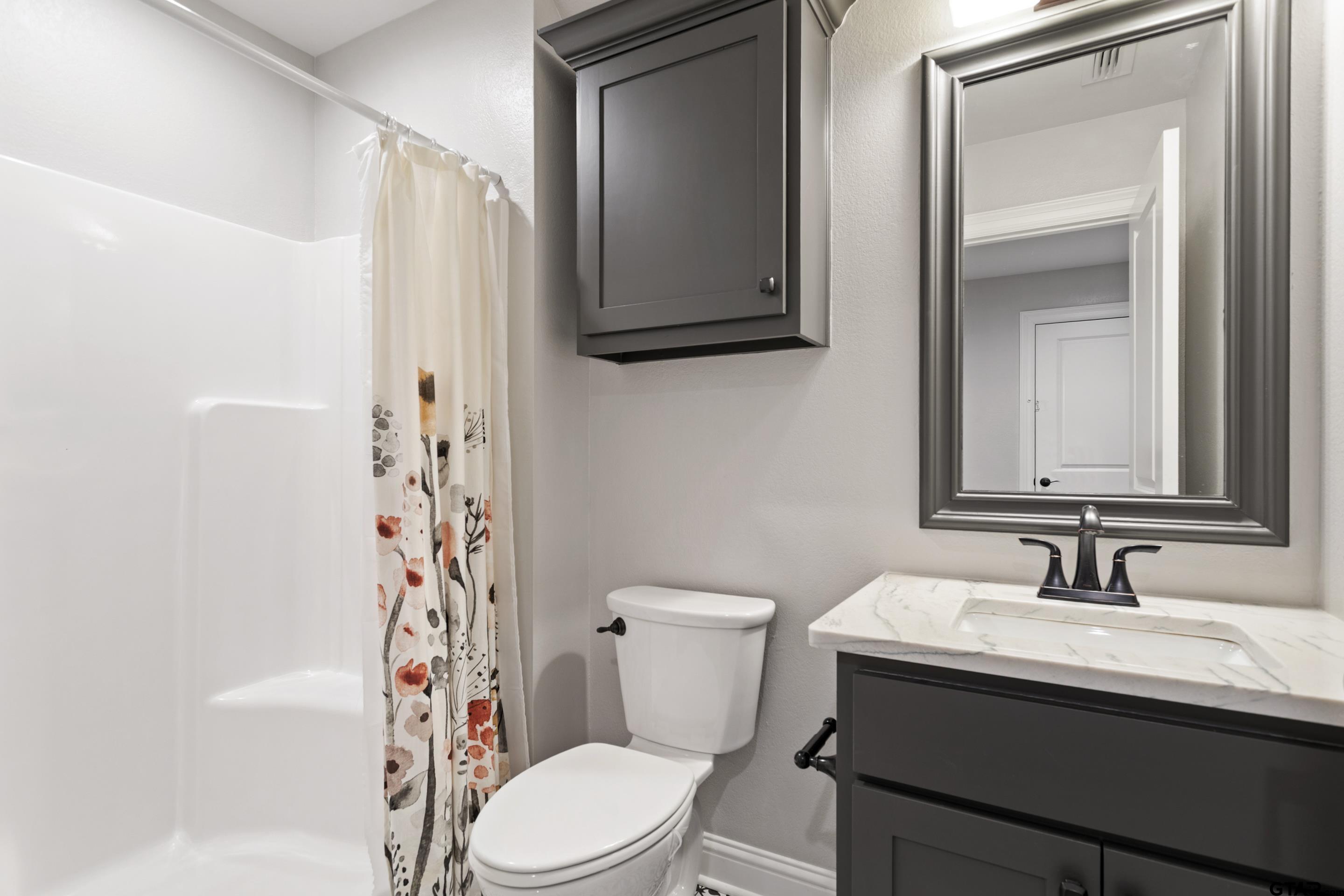 105 Nathan Road Chandler, TX 75758 - Photo 25 of 36 a bathroom with a sink a toilet and shower curtain